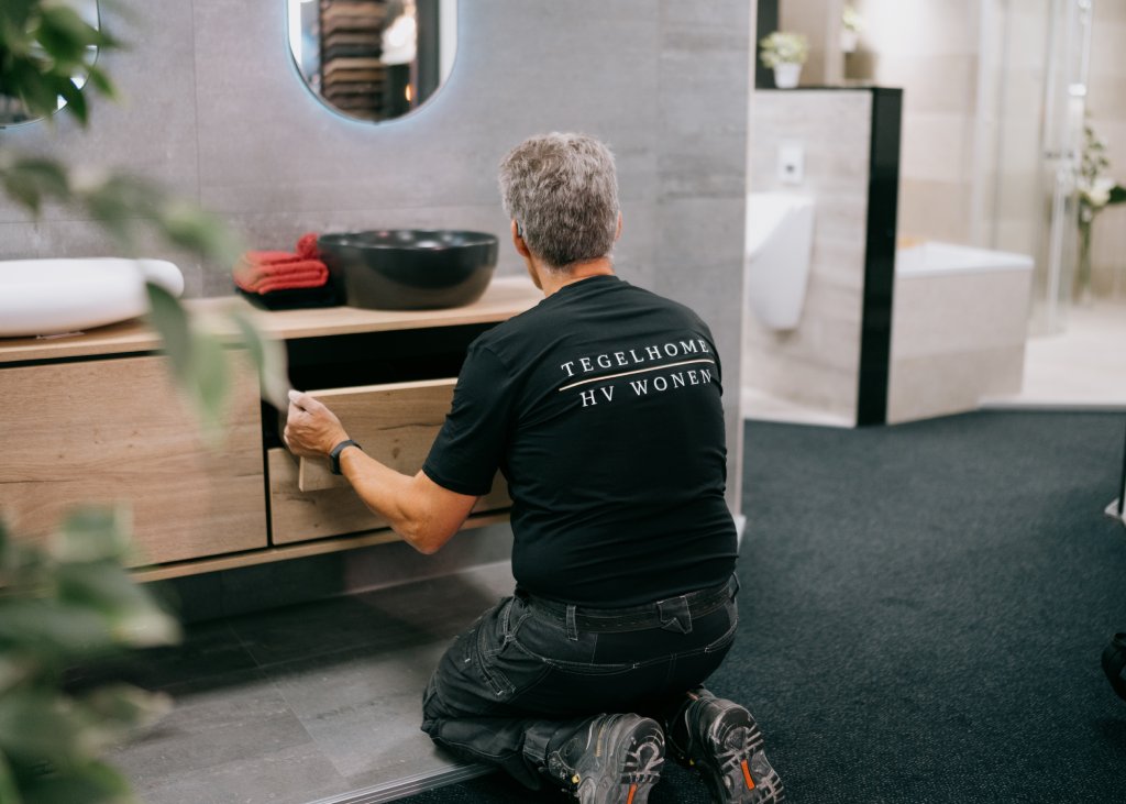 Wij bieden een complete badkamer inclusief montage aan in Zuidwolde. Monteur bezig met het monteren van een nieuw badkamermeubel.