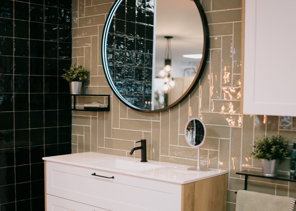 Een moderne badkamer met een wit wasmeubel en een ronde spiegel