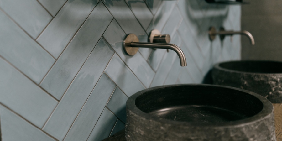 Realiseer vandaag nog uw droombadkamer in Nieuwleusen Close-up van een stijlvolle wasbak met een lichtblauwe betegelde muur.