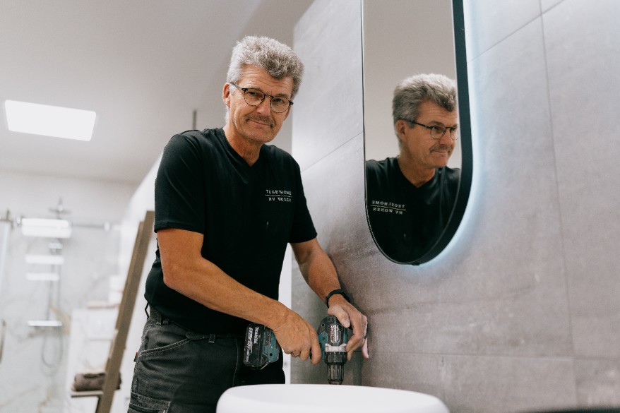 Badkamers in Hattem vakkundig gemonteerd door eigen specialisten Vakman van Tegelhome monteert een wastafel bij de installatie van badkamers in Hattem.