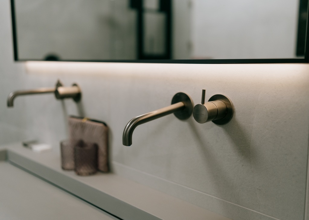 De kosten van een complete badkamer in Zuidwolde vertellen we u graag in de showroom. Close up van een chromen kraan van een badkamermeubel.