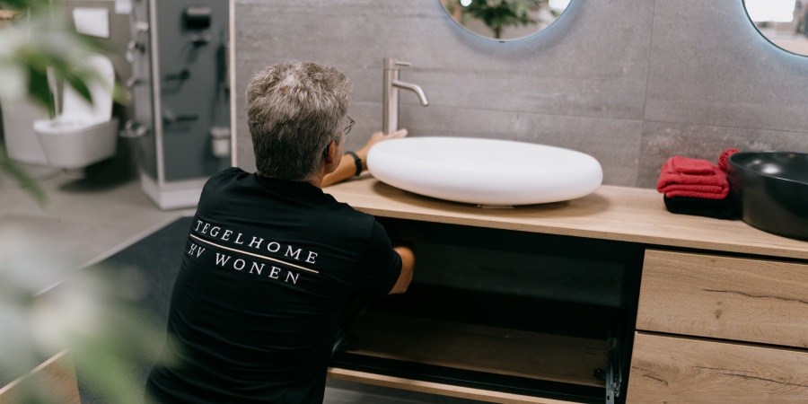 Uw badkamer inclusief montage in kampen begint bij Tegelhome Monteur van Tegelhome installeert badkamermeubel met sanitair.