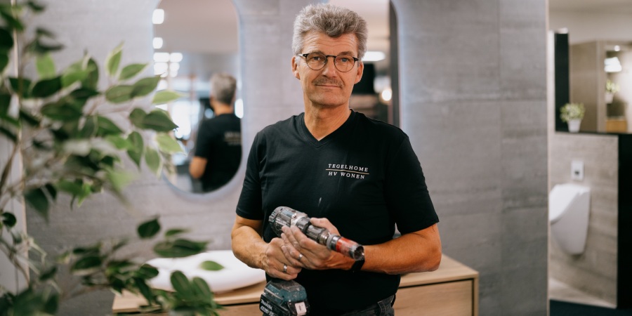 Uw badkamer in Kampen tot in de puntjes verzorgd door het team van Tegelhome Monteur van Tegelhome posseert voor de foto met een accuboor in zijn handen