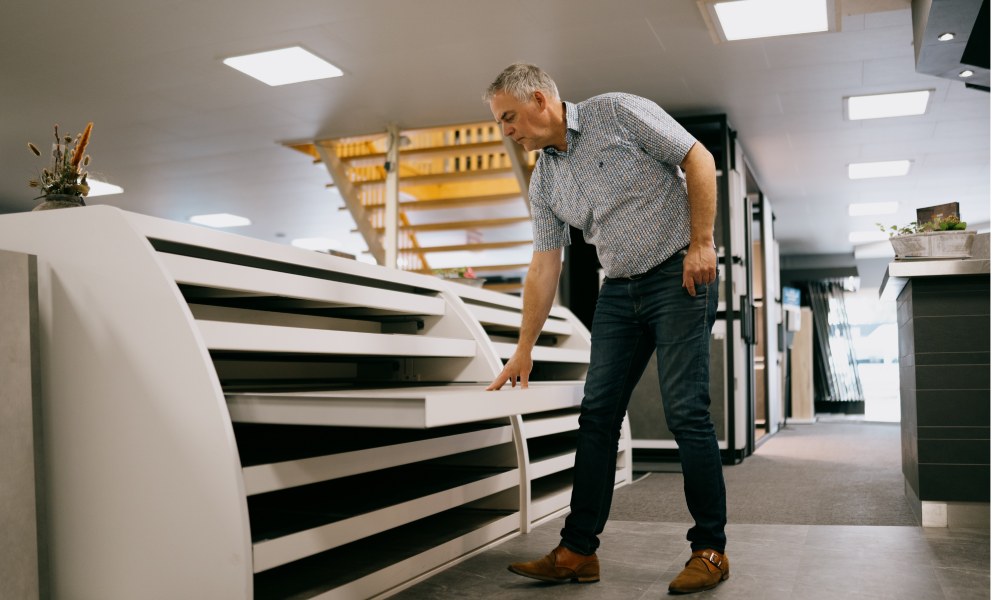 Plak PVC vloer uitzoeken bij Tegelhome showroom Persoon kijkt in de PVC vloeren showroom van Tegelhome