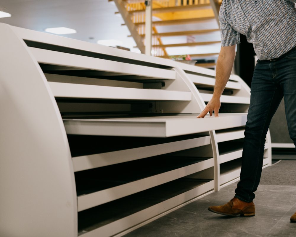 Een persoon bekijkt een showroom display met verschillende PVC vloeropties.