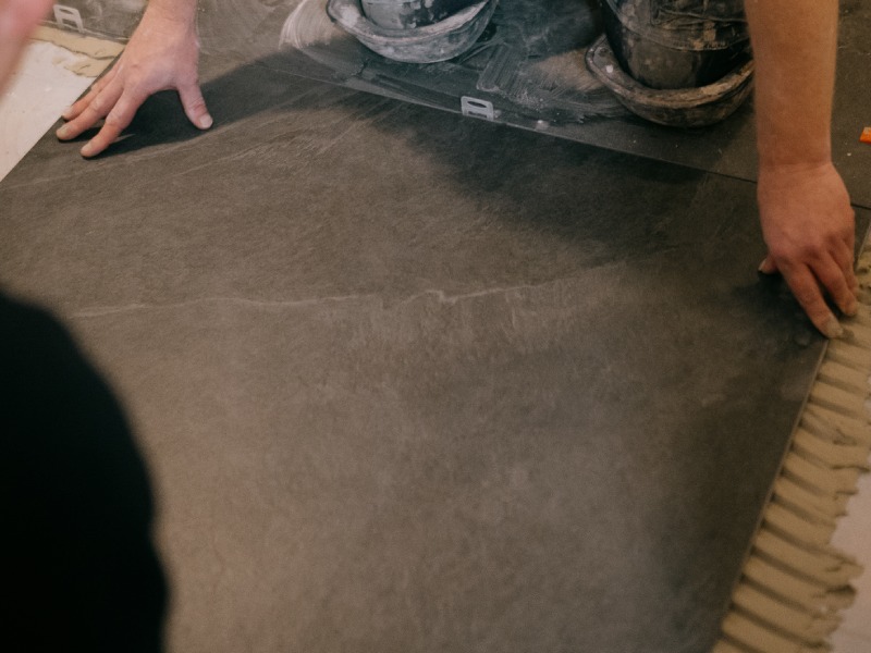 Vloerverwarming in Hoogeveen? Kies voor Tegelhome! Tegelzetters bezig met de installatie van een nieuwe vloer.