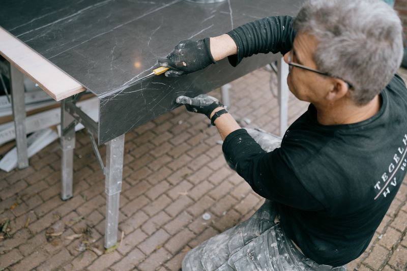 Naadloze integratie vloerverwarming met vloertegels in Hoogeveen Monteur van Tegelhome snijdt tegels op maat